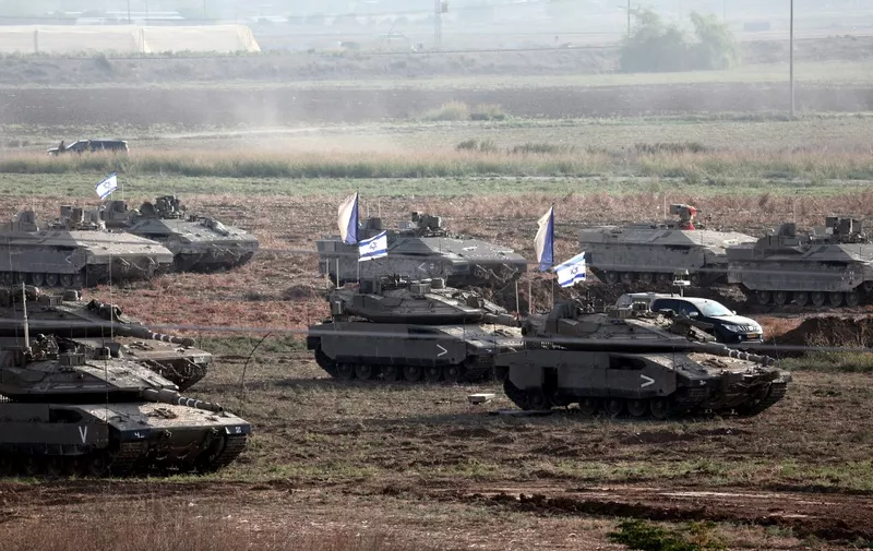 EDITORS NOTE: Graphic content / Israeli troops in tanks and other armoured vehicles amass in a field near the southern Israeli city of Ashkelon on October 14, 2023, as fighting between Israel and the Hamas movement continues for the eighth consecutive day. Thousands of Palestinians fled on October 14, to southern Gaza seeking refuge after Israel warned them to evacuate before an expected ground offensive against Hamas in retaliation for the deadliest attack in Israel's history. (Photo by Thomas COEX / AFP)