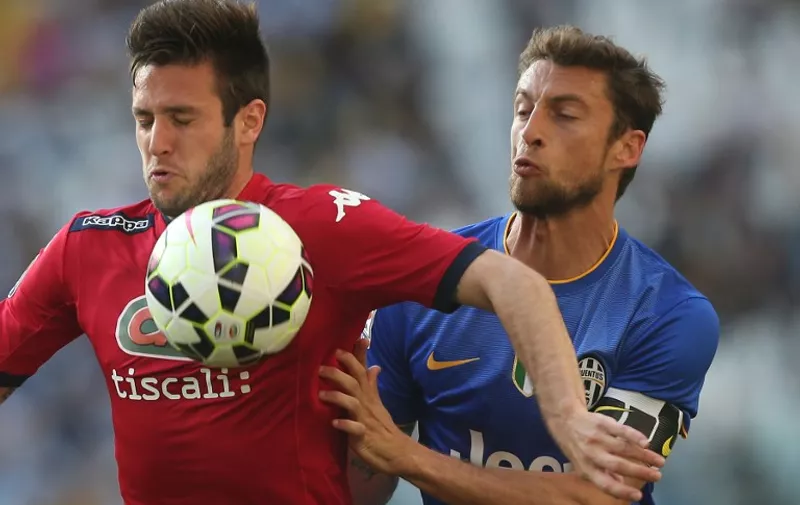 Cagliari's Croatian forward Duje Cop (L) fights for the ball with Juventus' midfielder Claudio Marchisio during the Italian Serie A  football match Juventus vs Cagliari on May 9, 2015 at the "Juventus Stadium" in Turin.  AFP PHOTO / MARCO BERTORELLO