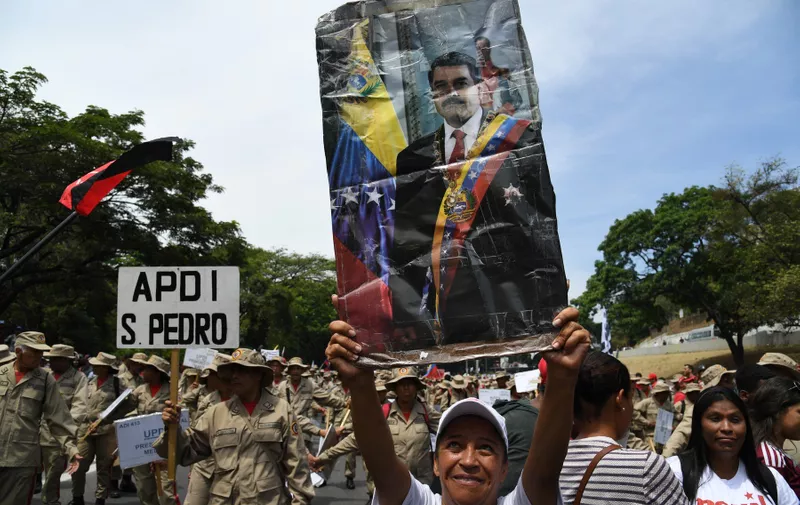 A supporter of Venezuelan President Nicolas Maduro displays a poster of Maduro during a rally on May Day in Caracas on May 1, 2019. Pro- and anti-government rallies were due to take place in Venezuela, a day after violent clashes erupted in the capital following opposition leader Juan Guido's call on the military to rise up against Maduro, who claimed the insurrection had failed., Image: 430205086, License: Rights-managed, Restrictions: , Model Release: no, Credit line: Profimedia, AFP