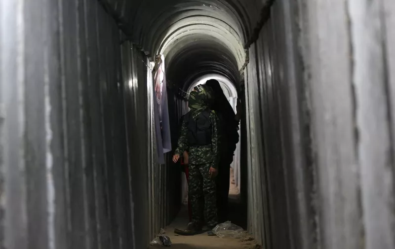 A Palestinian boy walks inside a tunnel used for military exercises during a weapon exhibition at a Hamas-run youth summer camp, in Gaza City, on July 21, 2016. (Photo by MOHAMMED ABED / AFP)