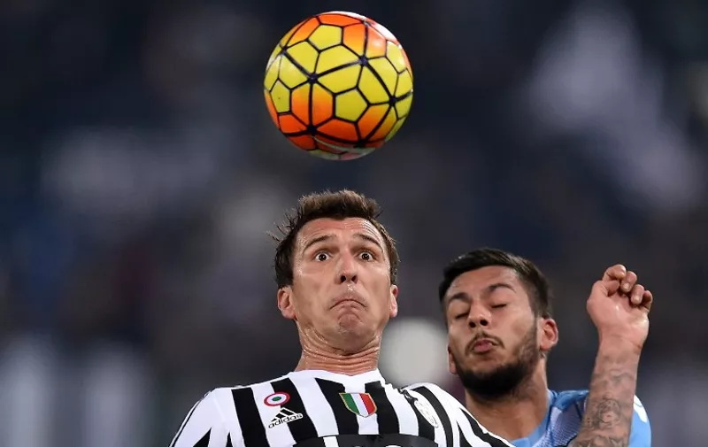 Juventus' forward from Croatia Mario Mandzukic (L) vies for the ball with Lazio's forward from Netherlands Ricardo Kishna during the Italian Serie A football match SS Lazio versus Juventus on December 4, 2015 at the Olympic stadium in Rome.  / AFP / ALBERTO PIZZOLI