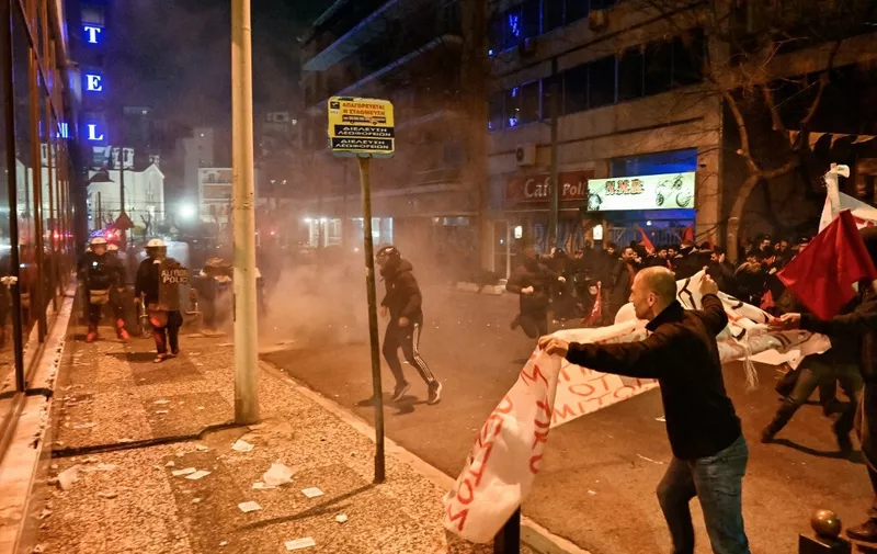Police throw tear gas towards protesters during a demonstration following a deadly train accident on February 28, 2023, near the city of Larissa, central Greece where 38 people died, outside the Hellenic Train headquarters, in Athens, on March 1, 2023. - Hundreds took to the streets in Athens, blaming the government for the privatisation of the Hellenic Train company after a deadly collision between two trains caused a derailment near the Greek city of Larissa late at night on February 28, 2023, authorities said. The Greek government announced 3 days of national mourning. (Photo by Louisa GOULIAMAKI / AFP)