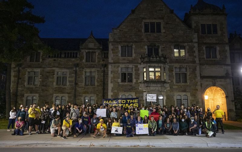 ANN ARBOR, MI - OCTOBER 13: A vigil for victims of sexual abuse is held across the street from the home of outgoing University of Michigan President Mark Schlissel October 13, 2021 in Ann Arbor, Michigan. Organizers say they are standing in solidarity with the victims of former UM sports doctor Robert Anderson, U.S. Womens Gymnastics Team doctor Larry Nassar, actor Bill Cosby, and others.   Bill Pugliano/Getty Images/AFP (Photo by BILL PUGLIANO / GETTY IMAGES NORTH AMERICA / Getty Images via AFP)