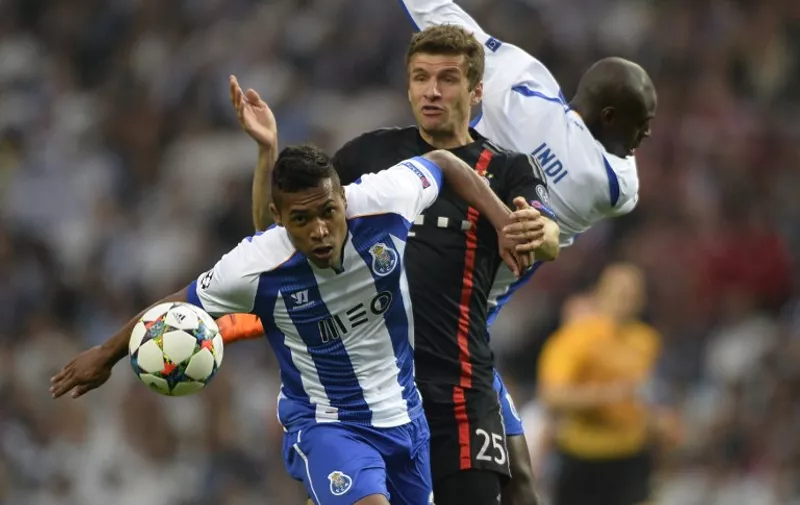 Porto&#8217;s Brazilian defender Alex Sandro (L) vies with Bayern Munich&#8217;s midfielder Thomas Mueller during the UEFA Champions League quarter final football match FC Porto vs FC Bayern Munich at the at the Dragao stadium in Porto on April 15, 2015. AFP PHOTO / MIGUEL RIOPA