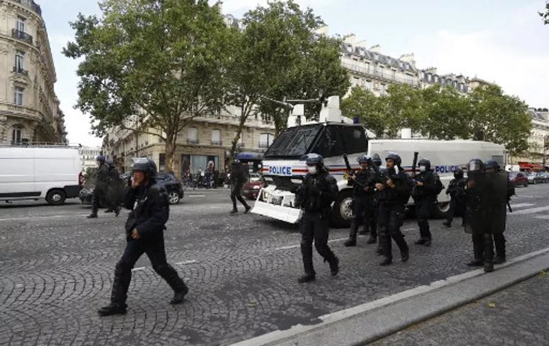 French policemen walk near a water truck during a demonstration against the compulsory vaccination for certain workers and the obligatory use of the health pass called for by the French government, in Paris on July 24, 2021. - Since July 21, people wanting to go to in most public spaces in France have to show a proof of Covid-19 vaccination or a negative test, as the country braces for a feared spike in cases from the highly transmissible Covid-19 Delta variant. (Photo by Sameer Al-DOUMY / AFP)