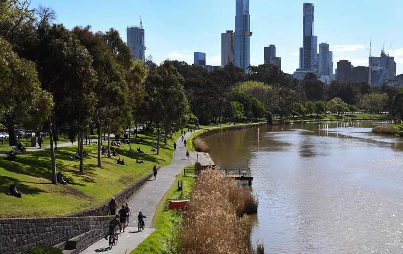 People exercise along the banks of the Yarra River in Melbourne on September 27, 2020 as an overnight curfew in Australia's second-biggest city will be lifted from September 28, almost two months after it was imposed to counter a surging COVID-19 coronavirus outbreak. (Photo by William WEST / AFP)