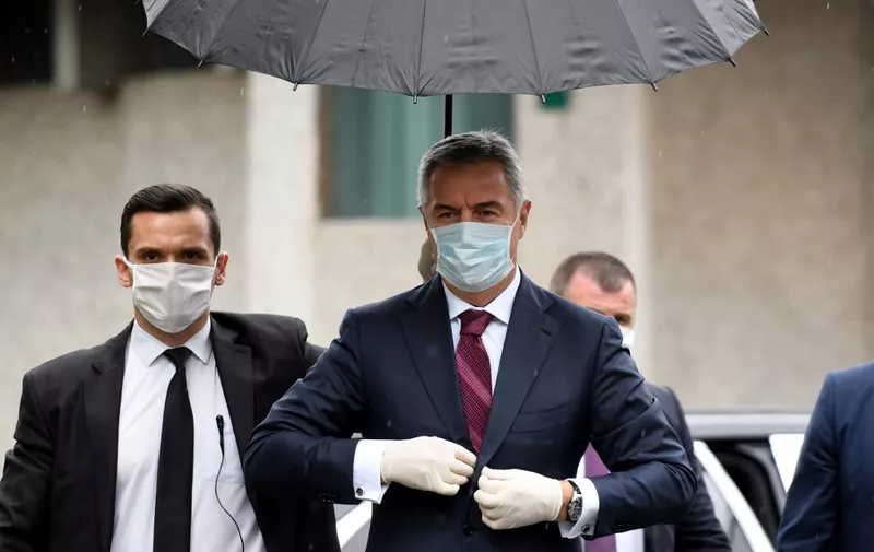 Montenegro's President Milo Djukanovic (C) arrives for a meeting at the Medical center in capital Podgorica, on March 27, 2020, amid the outbreak of COVID-19, caused by the coronavirus. - Montenegro, which has detected 70 confirmed infections of COVID-19 so far, issued strict measures, including a closure of schools, ban on public gatherings, and restrictions of land and sea passenger transport. (Photo by Savo PRELEVIC / AFP)
