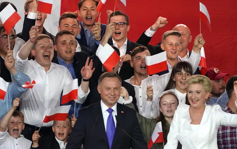 Polish President Andrzej Duda flashes V-signs after addressing supporters with his wife Agata as exit poll results were announced during the presidential election in Pultusk, Poland, on July 12, 2020. - Poland's right-wing head of state Andrzej Duda was ahead by a tiny margin in the presidential run-off against Warsaw's liberal mayor, an exit poll on on July 12, 2020 showed, starting a tense wait for the official results (Photo by JANEK SKARZYNSKI / AFP)
