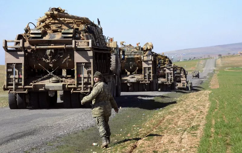 Turkish Army vehicles and tanks move near the Syrian border in Suruc on February 23, 2015 as almost 600 Turkish troops pushed deep into Syria in an unprecedented incursion on February 22, relocating a historic tomb and evacuating the soldiers guarding the monument after it was surrounded by Islamic State (IS) jihadists. The Damascus government, which no longer controls the area in Aleppo province but is at loggerheads with Ankara over the Syria conflict, lashed out at what it described as a "flagrant aggression" on Syrian territory.   AFP PHOTO / ILYAS AKENGIN
