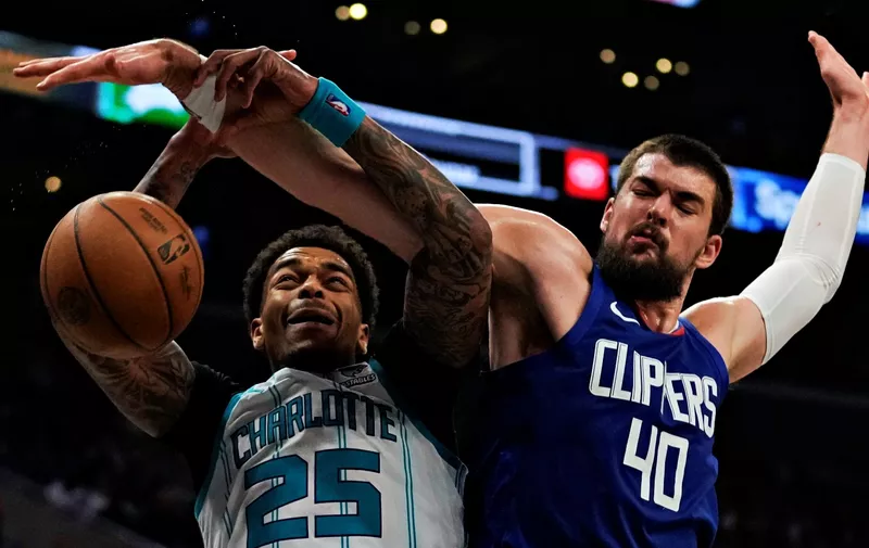 Los Angeles Clippers center Ivica Zubac (40) fouls Charlotte Hornets forward P.J. Washington (25) during the second half of an NBA basketball game in Los Angeles, Tuesday, Dec. 26, 2023. (AP Photo/Ashley Landis)