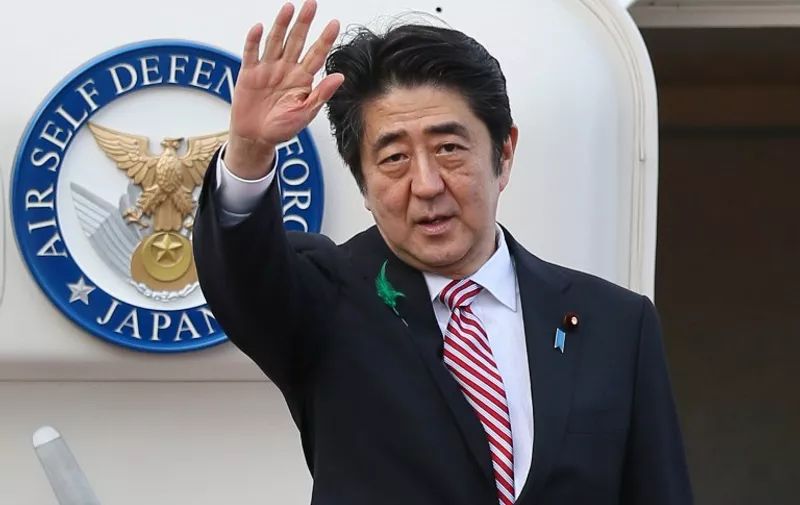 Japanese Prime Minister Shinzo Abe waves as he leaves to Indonesia at the Tokyo International Airport in Tokyo on April 21, 2015. Abe will attend the Asian-African Summit in Jakarta. AFP PHOTO / JIJI PRESS JAPAN OUT