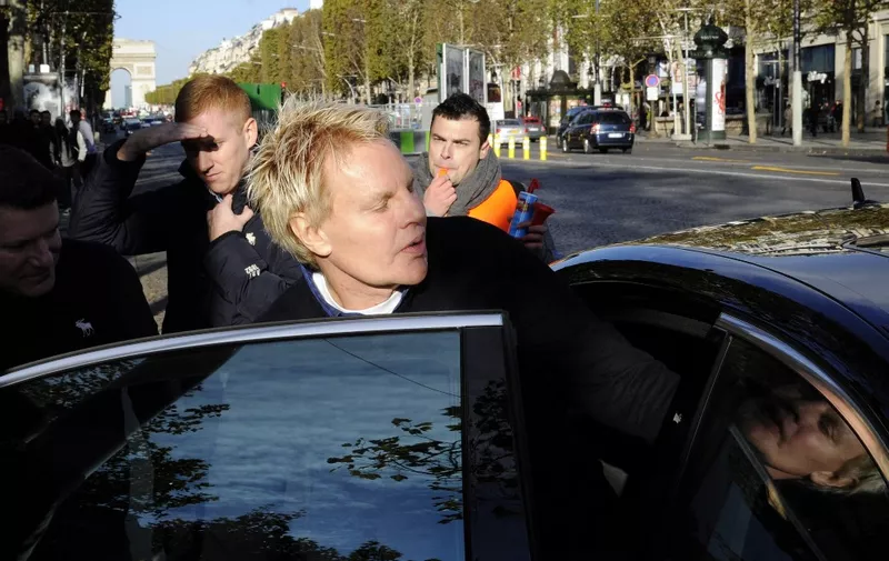 US Mike Jeffries, CEO of US clothing retailer Abercrombie &amp; Fitch leaves the store on the Champs Elysees avenue in Paris on October 27, 2012, as some workers protest against their working conditions. They declared the management did not respect French social rules.   AFP PHOTO BERTRAND GUAY (Photo by BERTRAND GUAY / AFP)