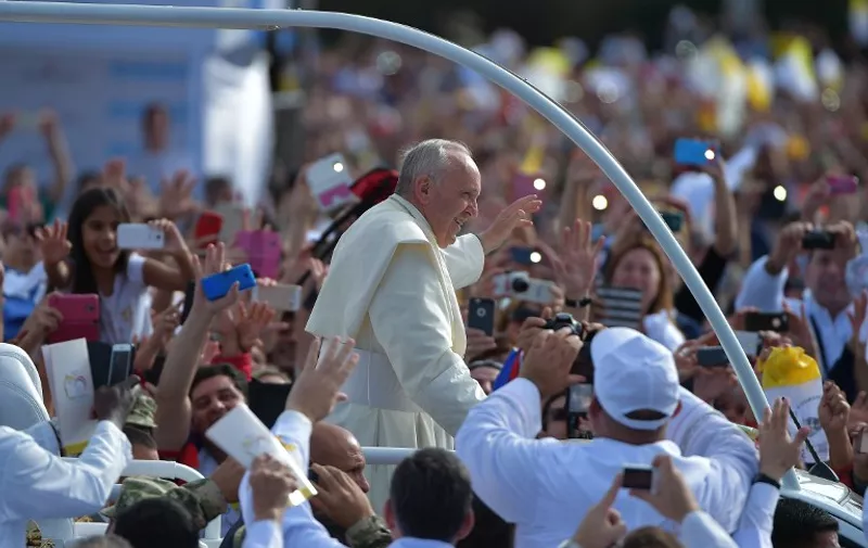 Pope Francis waves as he arrives to deliver a mass at Nu Guazu field in the outskirts of Asuncion, Paraguay on July 12, 2015. The Pope finishes Sunday his Latin American tour. AFP PHOTO / VINCENZO PINTO