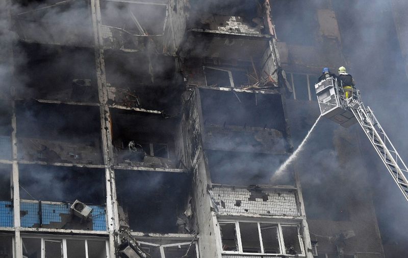 Ukrainian rescuers extinguish a fire in a residential building following a missile attack in Kyiv on February 7, 2024, amid the Russian invasion of Ukraine. At least three people were killed in a "massive" wave of Russian missile and drone attacks across Ukraine early on February 7, 2024, President Volodymyr Zelensky said. (Photo by Sergei SUPINSKY / AFP)