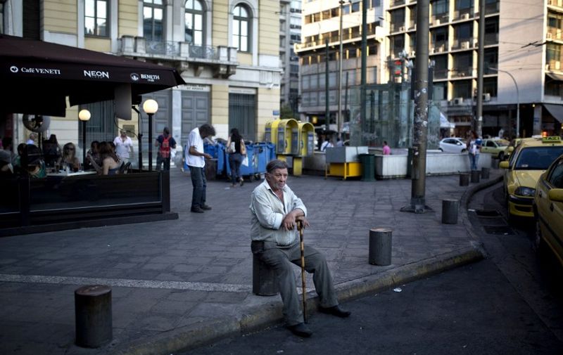 A man rests at the Omonia square in central Athens on July 16, 2105. Early elections were inevitable in Greece, analysts and a minister said on July 16 after Prime Minister Alexis Tsipras faced a mutiny from dozens of outraged government lawmakers as he passed creditor-mandated austerity reforms through parliament. AFP PHOTO / ANGELOS TZORTZINIS