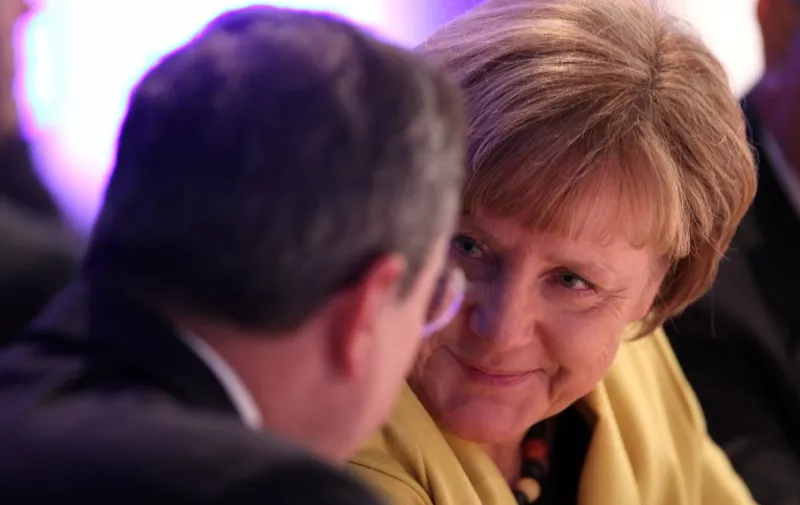 German Chancellor Angela Merkel (R) talks to the European Central Bank (ECB) President Mario Draghi during the 2015 opening ceremony of the Deutsche Boerse Group in Eschborn near Frankfurt, Germany, on January 19, 2015. AFP PHOTO / DANIEL ROLAND / AFP PHOTO / DANIEL ROLAND