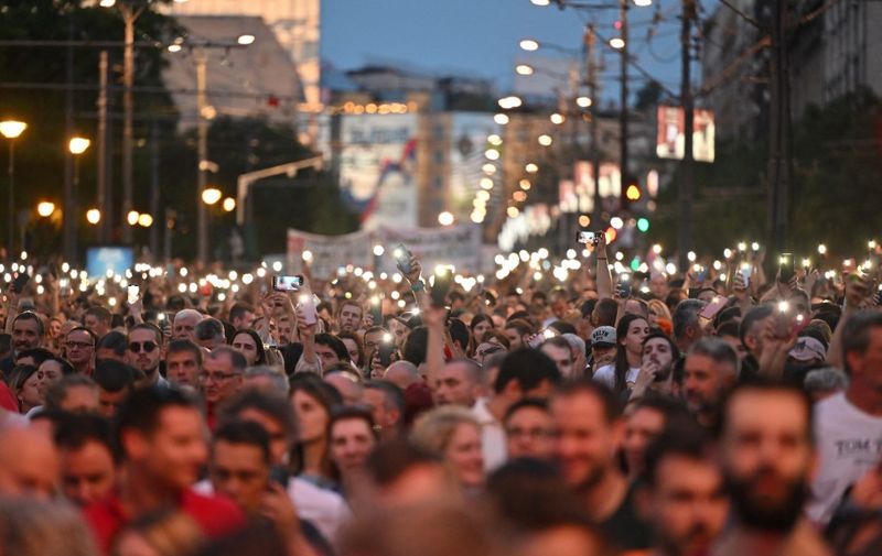 Protesters light up their smartphone flash in the air during a rally to call for the resignation of top officials and curtailing violence in the media, a month after two back-to-back shootings that killed 18 people, in Belgrade, on June 9, 2023. Protesters took part in the sixth "Serbia against violence" rally, one of the biggest rallies the country has seen in over two decades. The demonstrations have tapped into simmering anger at the ruling party over what protesters say is a culture of violence fanned by the government and the media outlets they control. (Photo by ANDREJ ISAKOVIC / AFP)