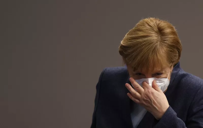 (FILES) In this file photo taken on December 16, 2020 German Chancellor Angela Merkel puts her face protection mask on after a session of the Bundestag (lower house of parliament) in Berlin, amid the coronavirus Covid-19 pandemic. - Chancellor Angela Merkel on January 16, 2021 said significantly tougher measures were needed to slow Germany's coronavirus infections, party sources told AFP. Speaking at a meeting with top brass from her centre-right CDU party, Merkel said "the virus can only be stopped with significant additional efforts", participants told AFP, adding that the chancellor wanted to hold fresh crisis talks with regional leaders next week. (Photo by Odd ANDERSEN / AFP)