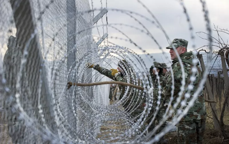 Macedonian soldiers build a second border fence to prevent illegal crossings by migrants at the Greek-Macedonian border near Gevgelija on February 8, 2016.
Macedonia started on February 8, 2016 erecting double razor fence,digging holes, erecting pillars, erecting razor fence and is extending fence on new places along side by Greek border line. / AFP / Robert ATANASOVSKI
