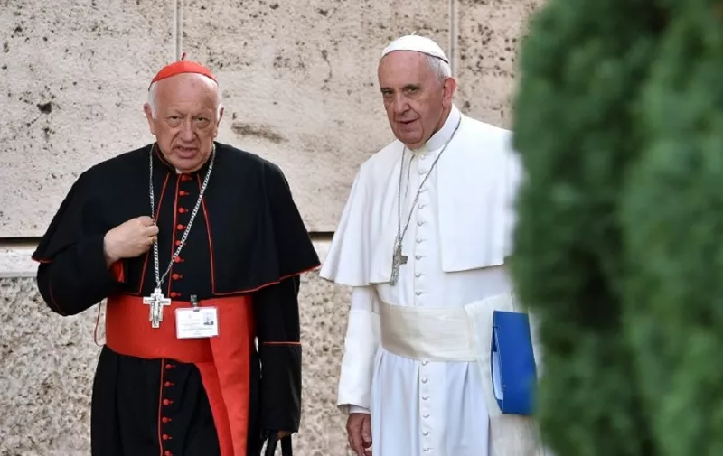 Pope Francis (R) talks with Chilean cardinal Ricardo Ezzati Andrello as arrives for the Synod on the family, at the Vatican, on October 5, 2015. Pope Francis said on October 5 that the Church was "not a museum" but a place for progress, as members of a key synod started three weeks of debate aimed at reshaping Catholic teaching on the family.   AFP PHOTO / ALBERTO PIZZOLI (Photo by ALBERTO PIZZOLI / AFP)